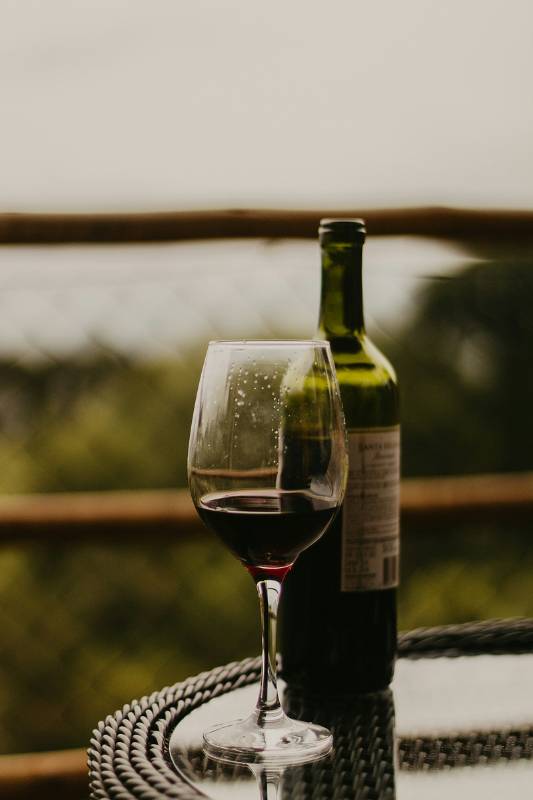 A bottle of red wine and a poured glass