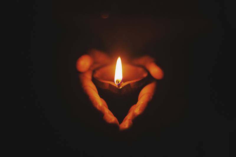 Candle glowing warmly in the dark